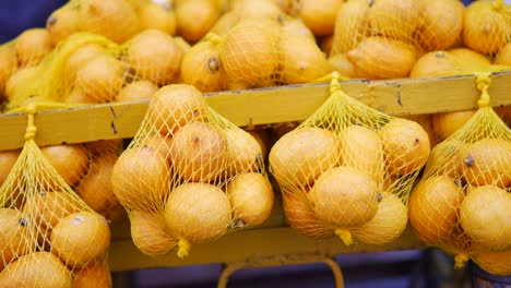 yellow lemons in net bags at a market