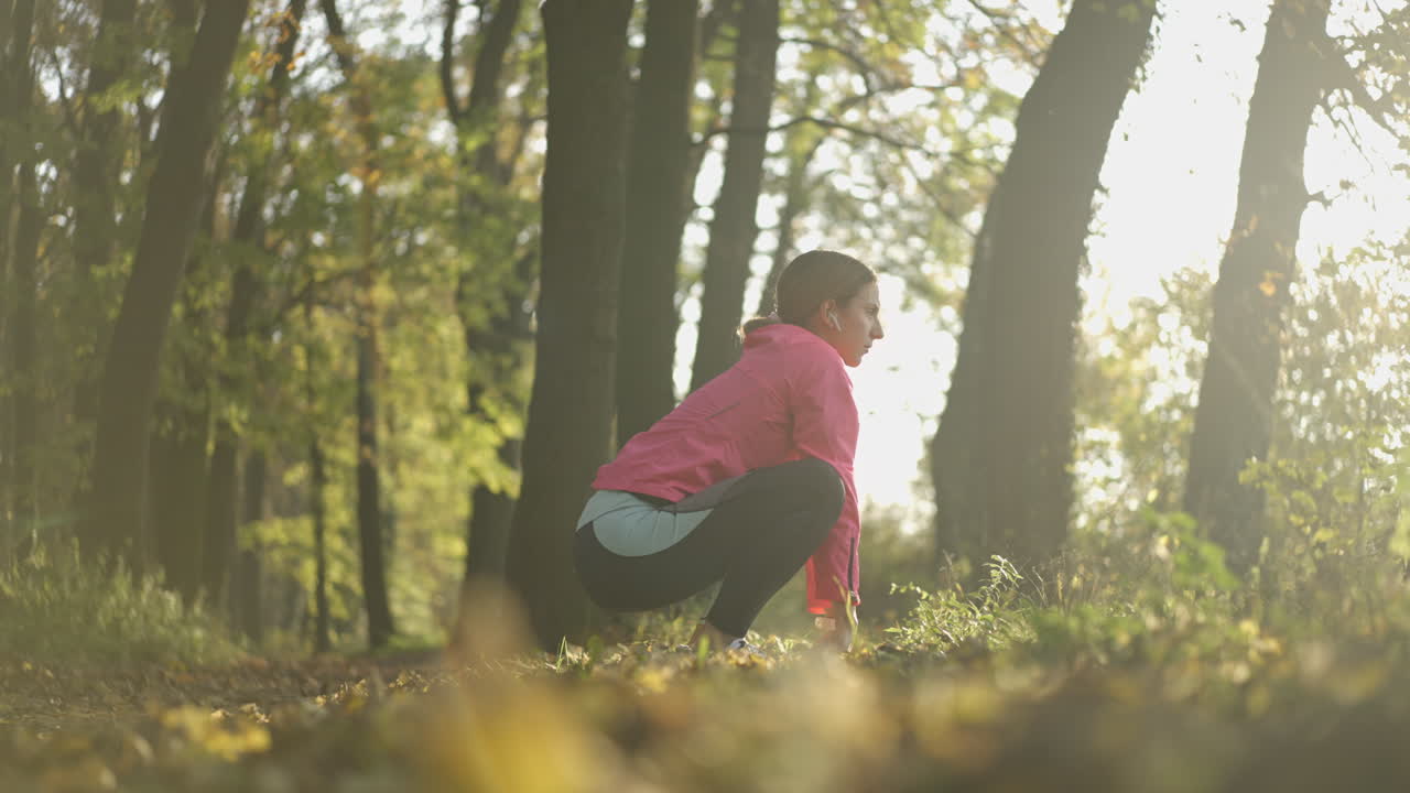 Woman doing warm-up exercises in an autumn park