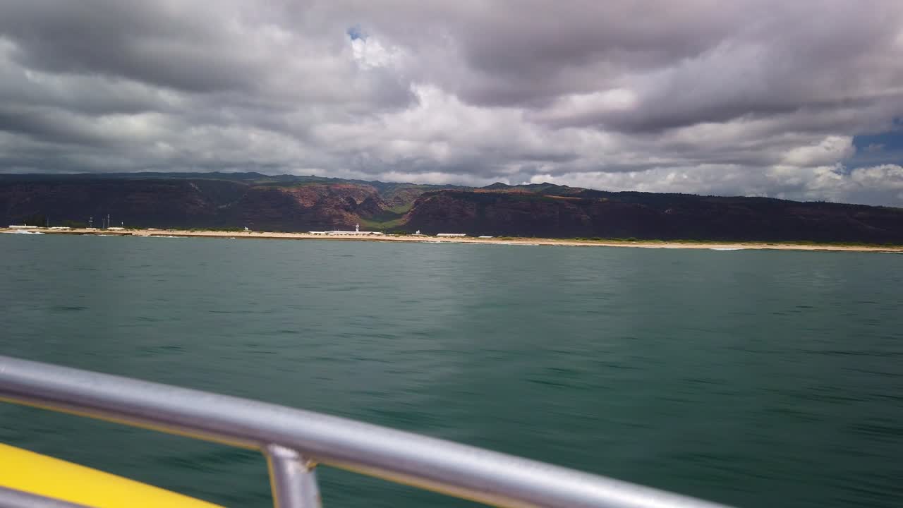 Gimbal wide shot from a moving speed boat of a naval base and Waimea Canyon off the coast of Kaua'i, Hawai'i