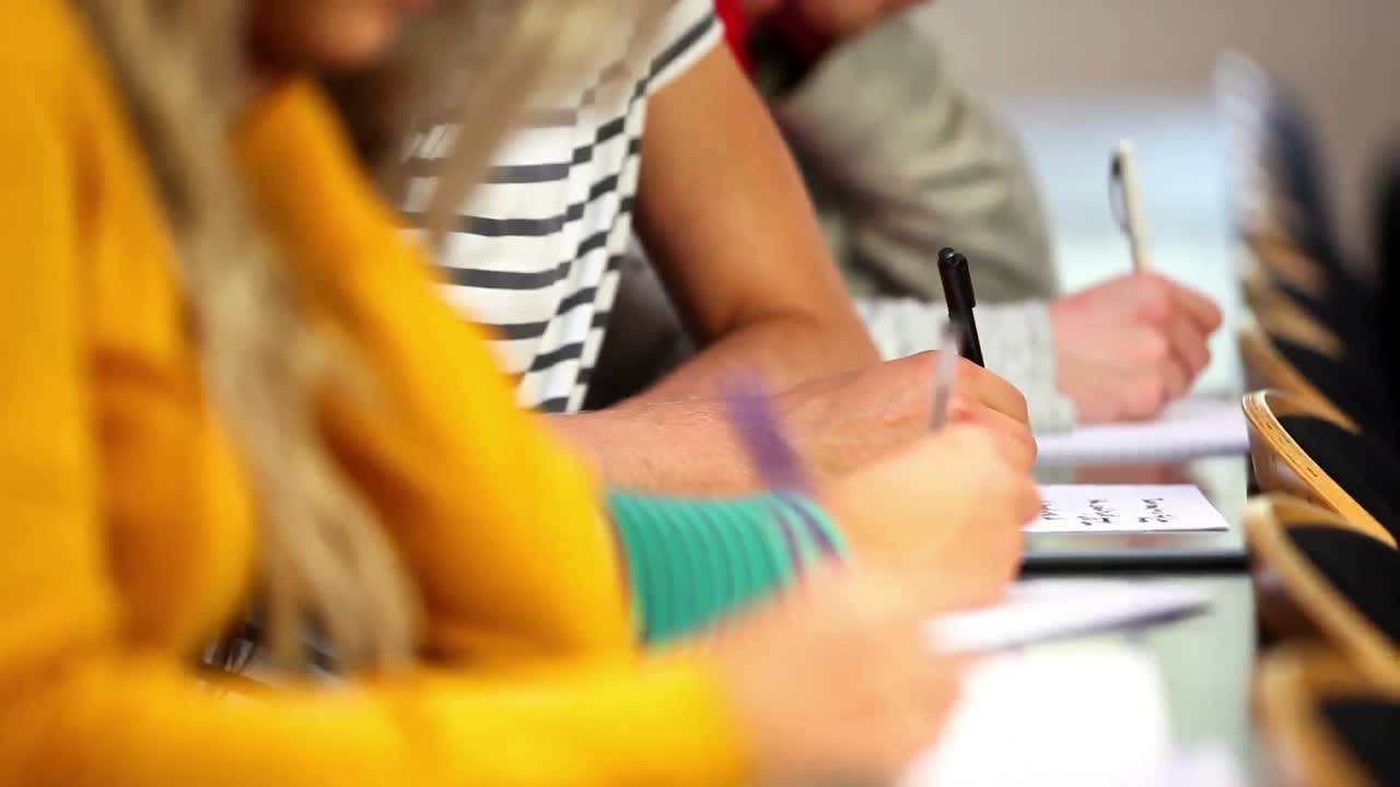 fila de estudiantes tomando notas en el aula