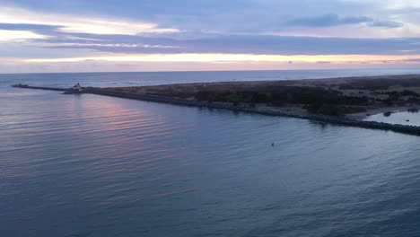 Vista-Lejana-De-La-Luz-De-Bandon-A-Lo-Largo-Del-Río-Coquille-En-Oregon-Durante-La-Puesta-De-Sol-De-La-Hora-Azul---Drone-Aéreo