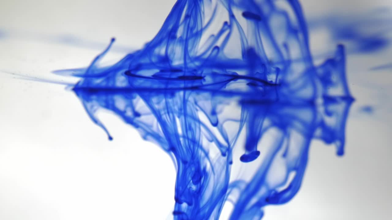 reflejo en un acuario de humo coloreado sobre un fondo blanco, derrames de pintura coloreada sobre un líquido transparente, gota de tinta azul cayendo en el agua, gotas de pintura acuática