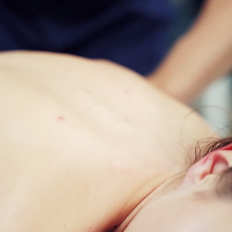 therapist's hands doing healthy massage on the female's back outside. young woman relaxing while receiving body massage. close-up
