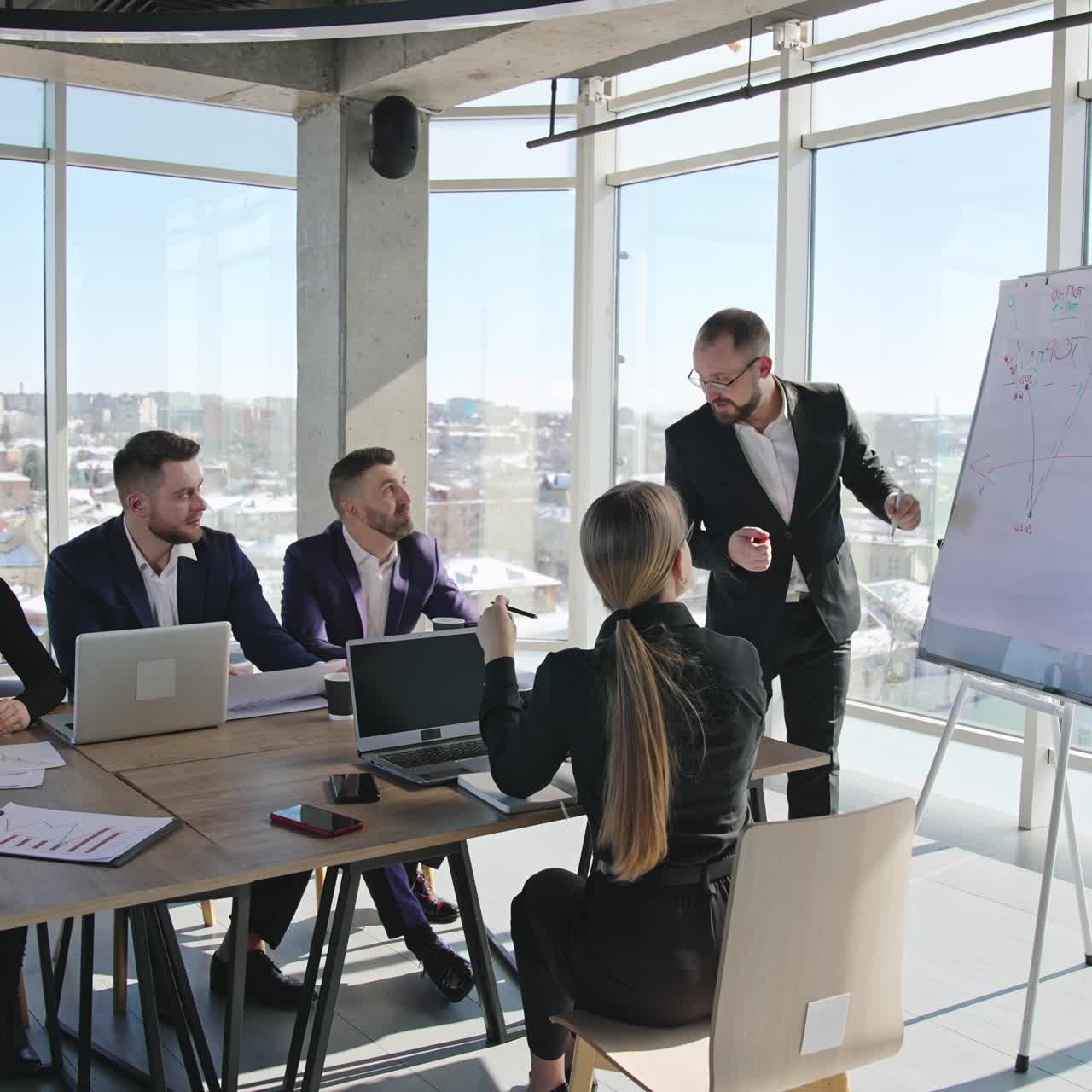 Teamwork in the meeting room. Developing strategies and new ideas using chart. Team of professionals in the light office