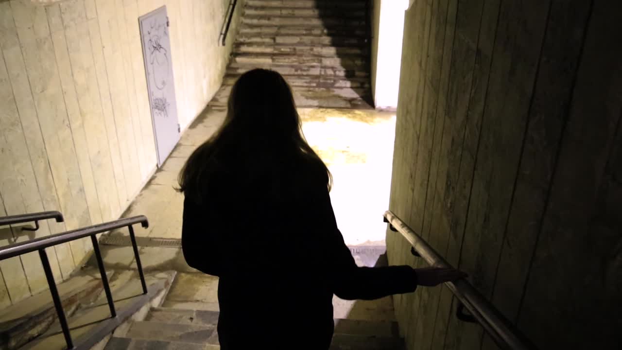 Girl walking down to the underground passage at night