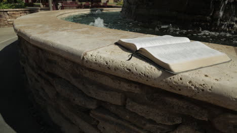 holy book by a peaceful water fountain background