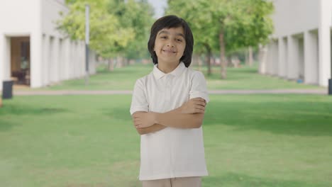 Happy-Indian-boy-standing-crossed-hands-in-park