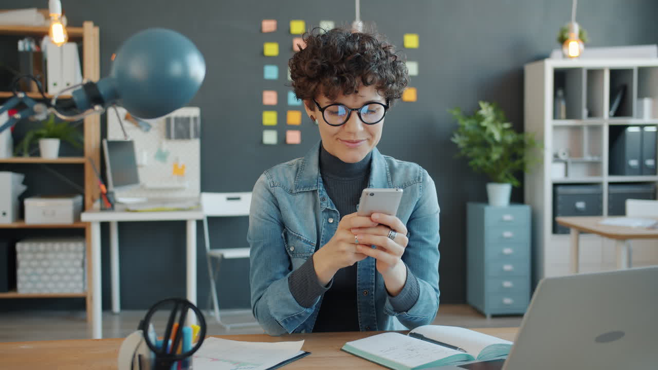 mujer usando un teléfono inteligente en una oficina moderna