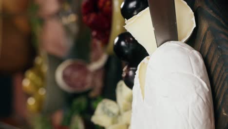 close up of charcuterie board with cheese, fruit, and knife