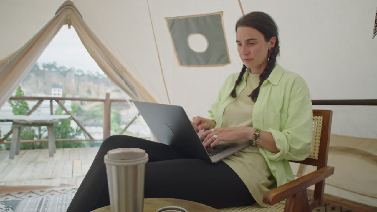 Girl Sitting in Glamping Tent and Using Laptop