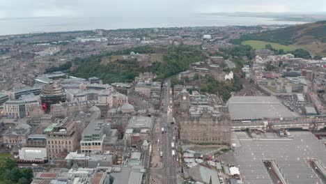 Dolly-forward-drone-shot-over-Princes-street-towards-Calton-hill-late-evening