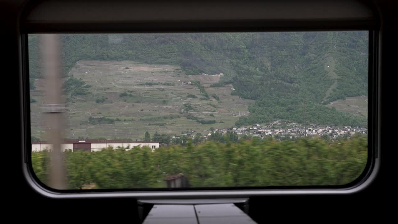 A scenic view passing through the beautiful Swiss countryside from the window of a business class train carriage on a journey across Switzerland