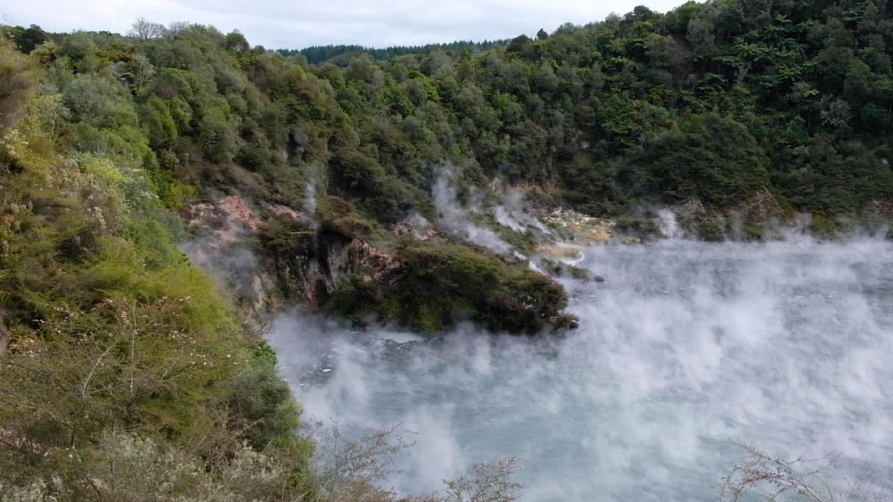 nubes de vapor caliente y brumoso que se elevan desde la piscina caliente sulfúrica del lago de sartén en el valle de la grieta volcánica de waimangu, rotorua, nueva zelanda aotearoa
