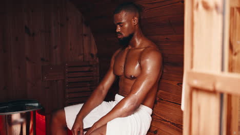 man relaxing in a wooden sauna