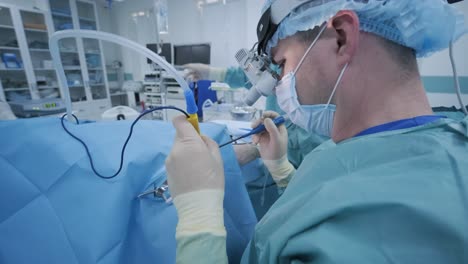 operation of removing tonsils under deep anesthesia, surgeon uses latest devices, cold plasma method, cuts swelling in throat, doctor works with new probe, medical headlamp, surgical loupes