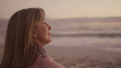 Active-senior-woman-sitting-on-beach