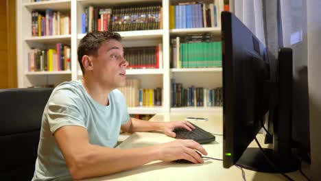 man reacting at computer in home office