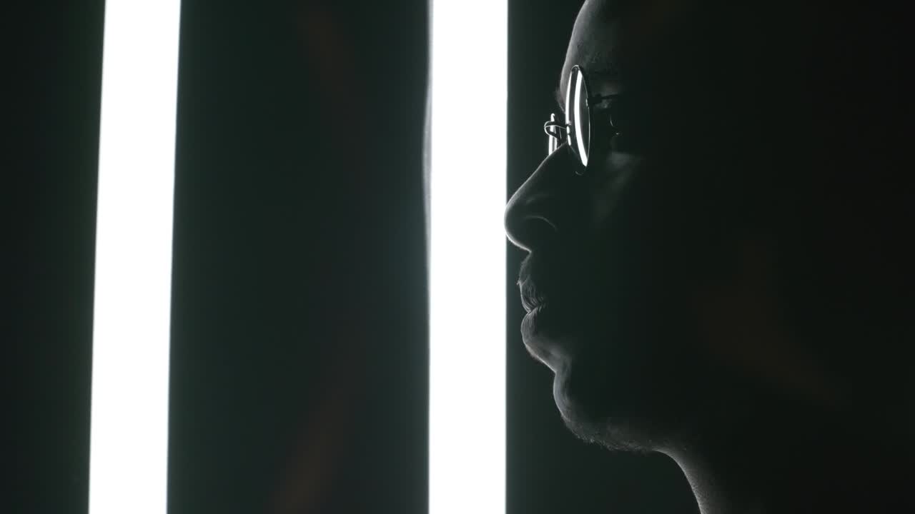 Man Posing in Dark Studio with Fluorescent Lamps