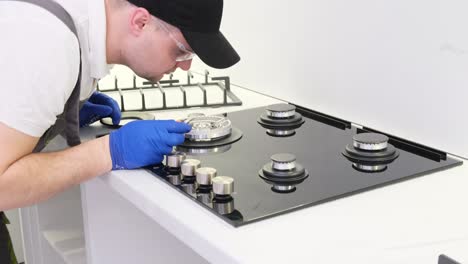a gas service worker repairs a gas stove