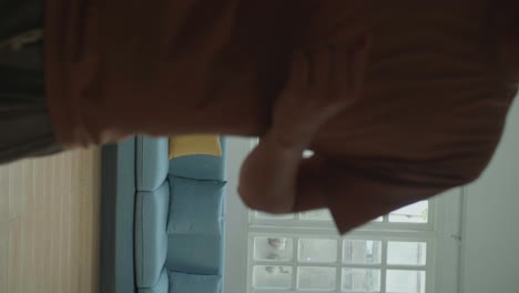 full body of asian man dancing while shooting video content for social networks at home
