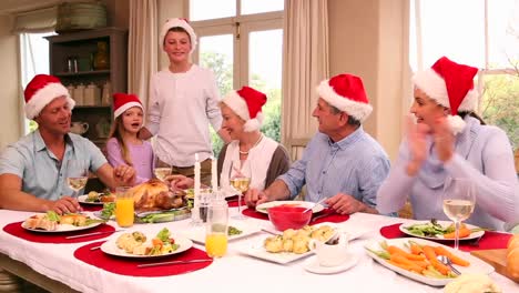 Familia-De-Tres-Generaciones-Cenando-Juntos-De-Navidad