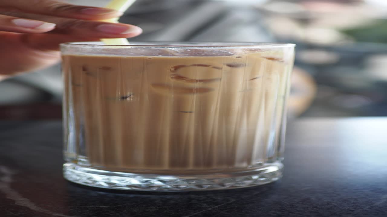 으로 얼음 커피 한 잔을 들고 있는 손