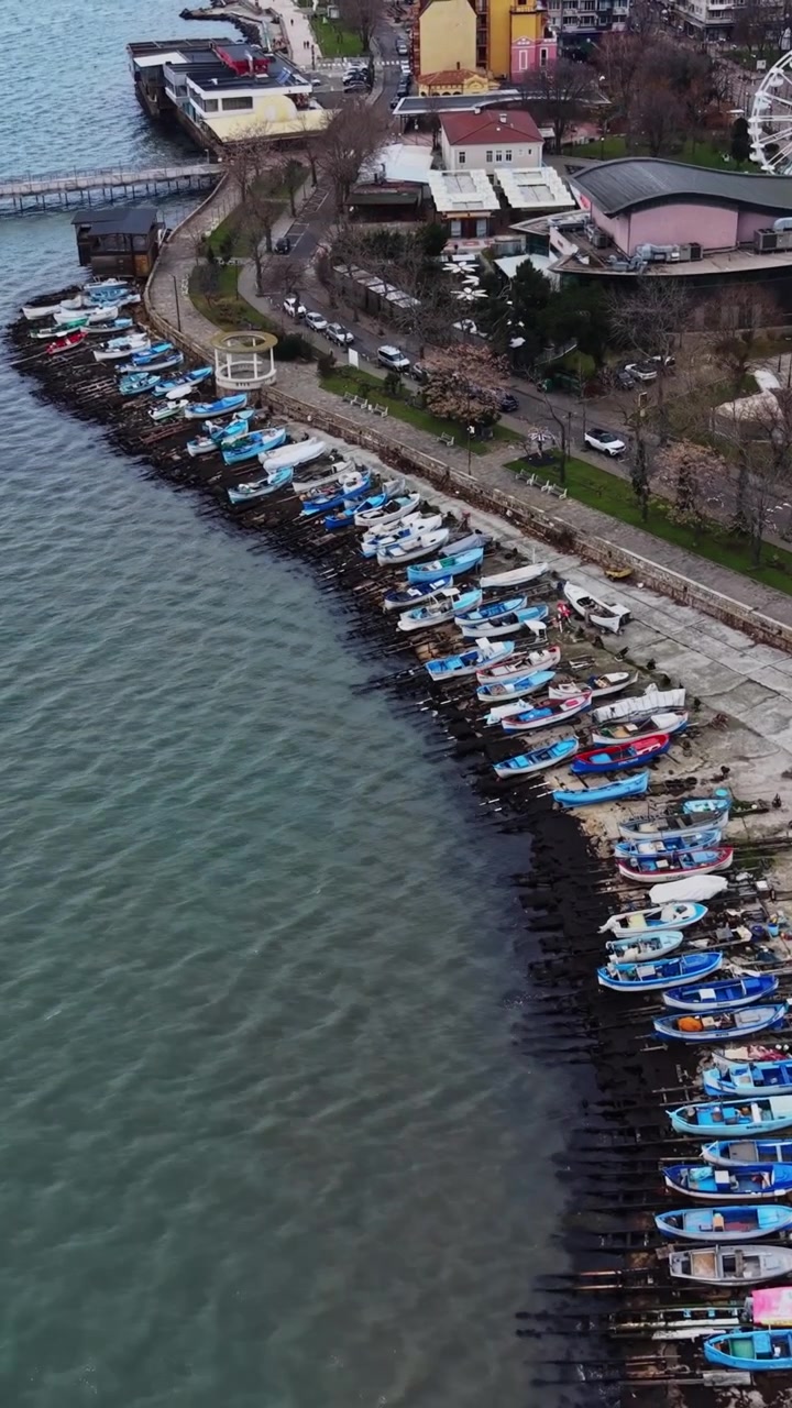 Barche allineate lungo la costa vicino a una città di sera