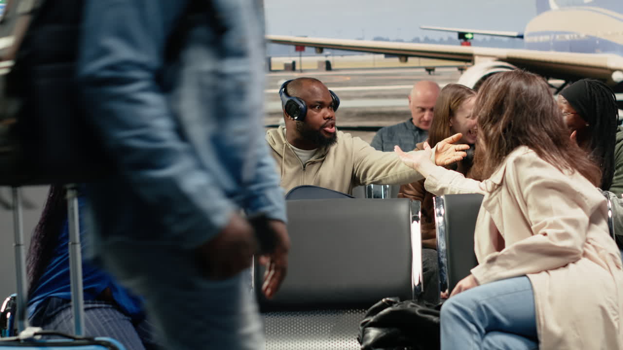 Multiethnic group of friends in airport chatting, waiting at departure gate