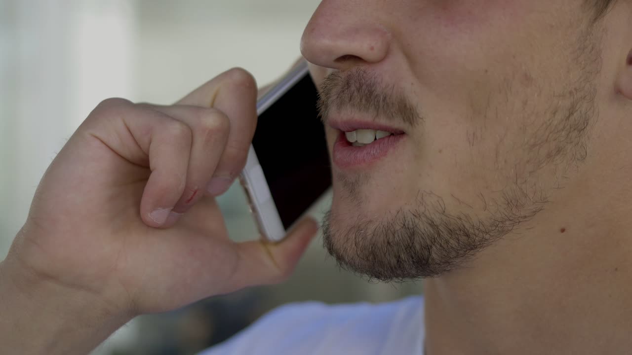Closeup shot of smiling young man talking on phone.