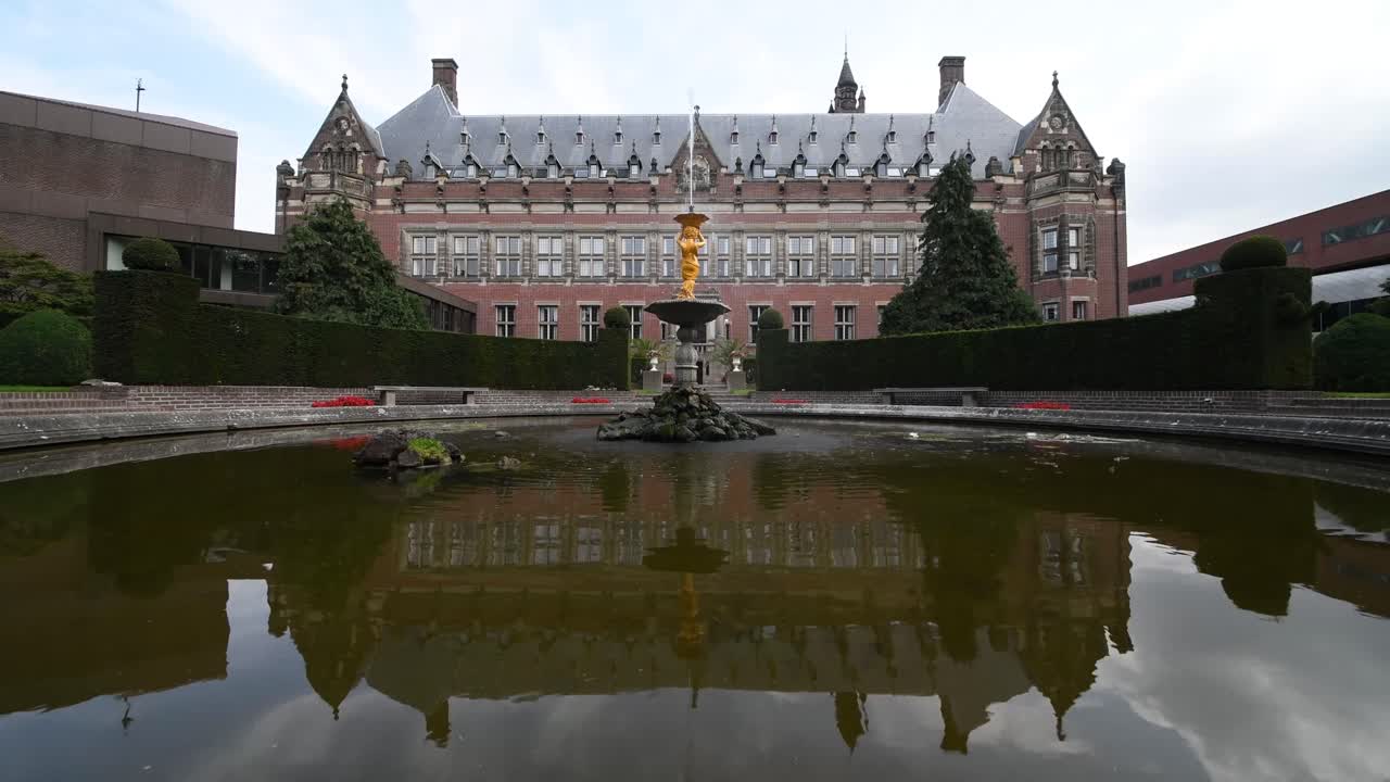 수련 꽃으로 덮여 있고 키 큰 나무로 둘러싸인 가운데 평화로운 분수 워터 제트