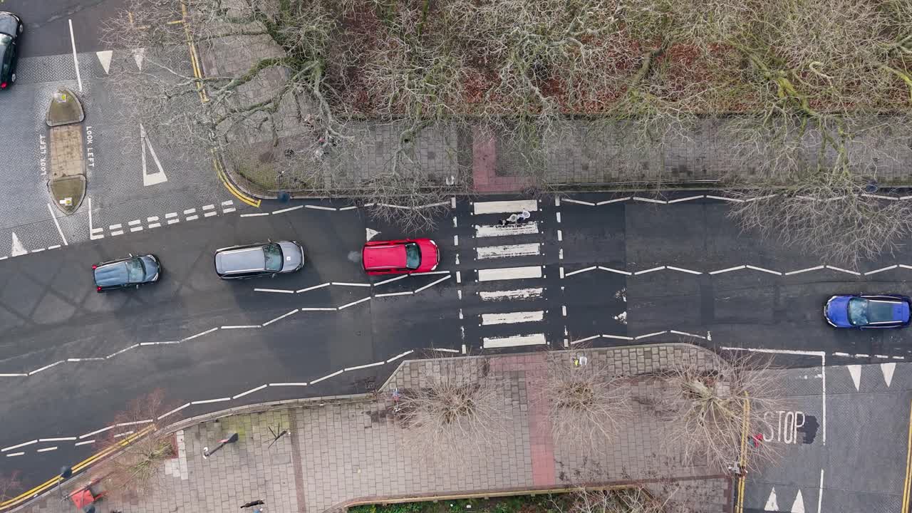 Drone top-down over cars stopping at zebra crossing for passenger