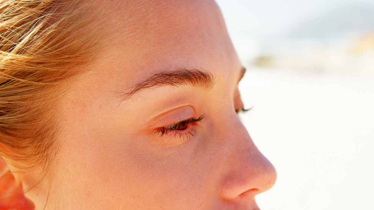 해변 4k에 서있는 젊은 백인 여성의 클로즈업