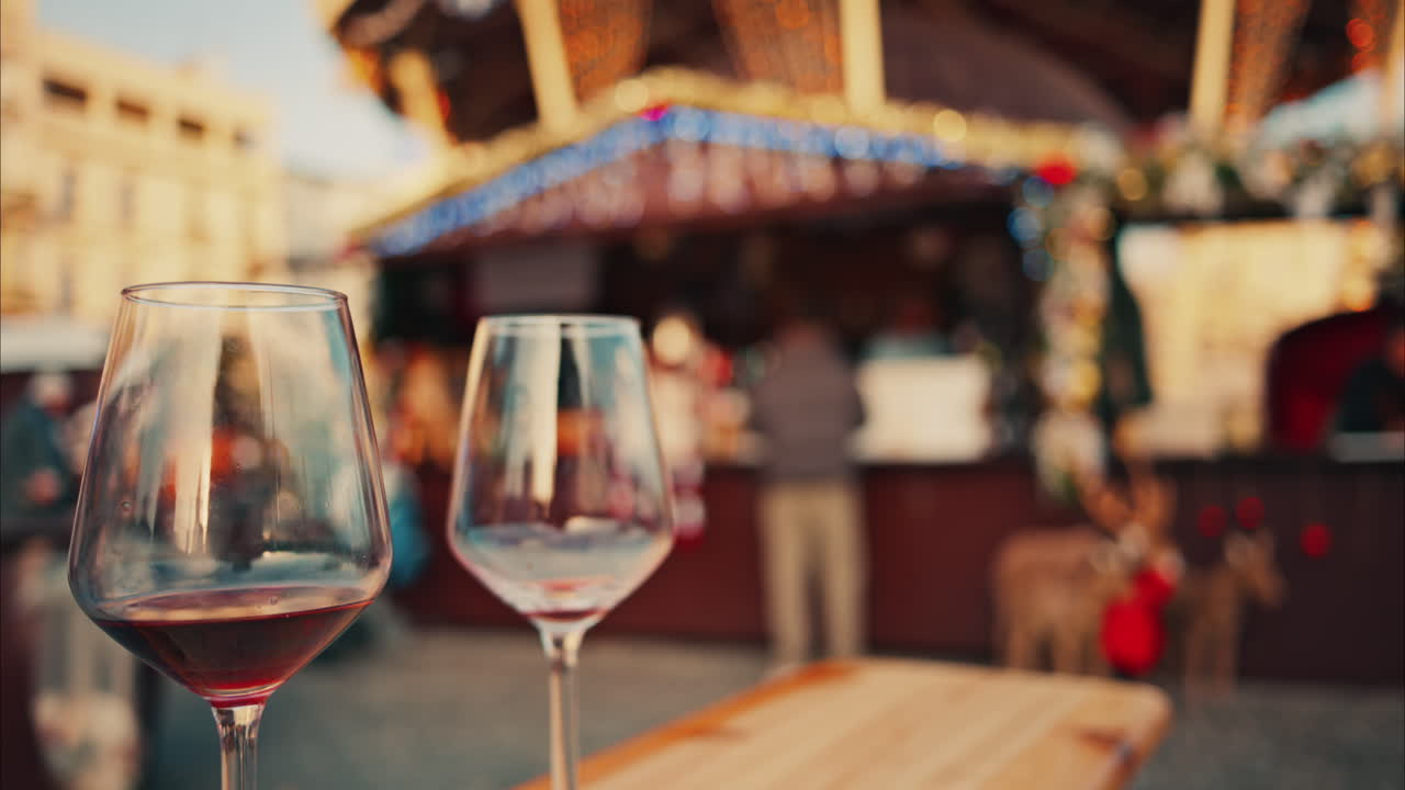 Close up of two glasses of red wine standing on the table at the Cannes Christmas Market with a blurry background