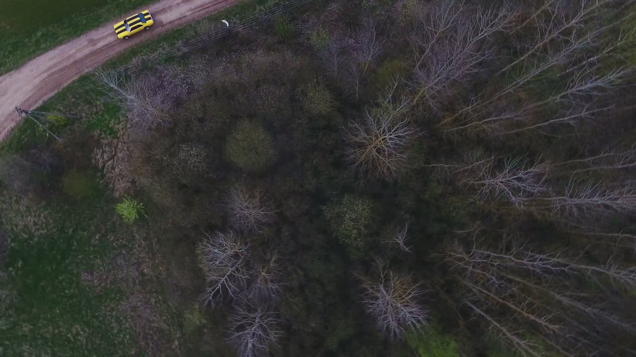 Yellow With Black Stripes Classic Ford Consul Rides On A Gravel Road. 4K Aerial Footage