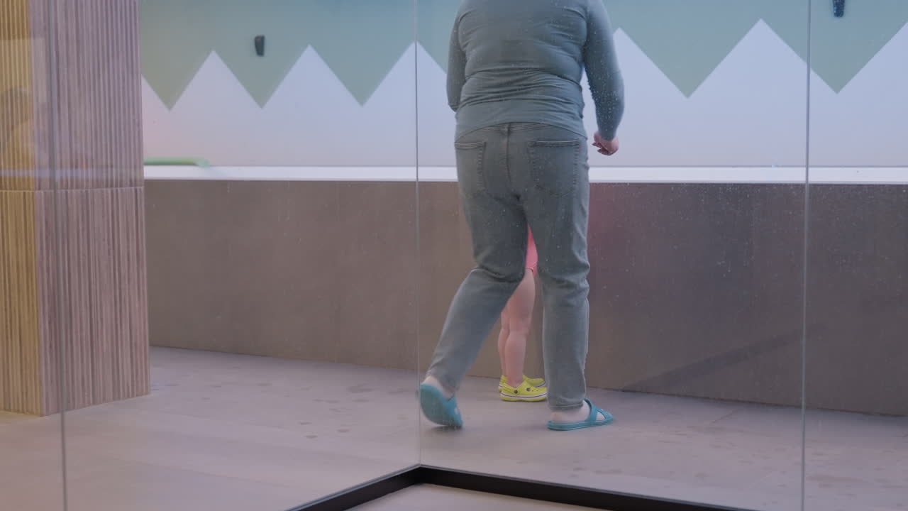 Baby mistakenly throws ball across to other side then looks back at nanny in surprise, small hands mid toss, wide eyes, gentle indoor light, family moment, playful reaction with soft background blur