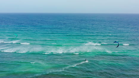 Cinematic-drone-shot-of-professional-kiters-surfing-at-tropical-island