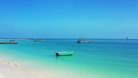 Playa-De-Arena-Paradisíaca,-Mar-Turquesa-Y-Barcos-De-Pesca-En-Una-Laguna-Tranquila