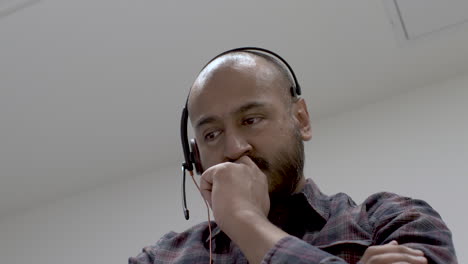 Anxious-Day-Trader-Wearing-Headset-With-Hand-On-Chin-Rocking-Back-And-Forth