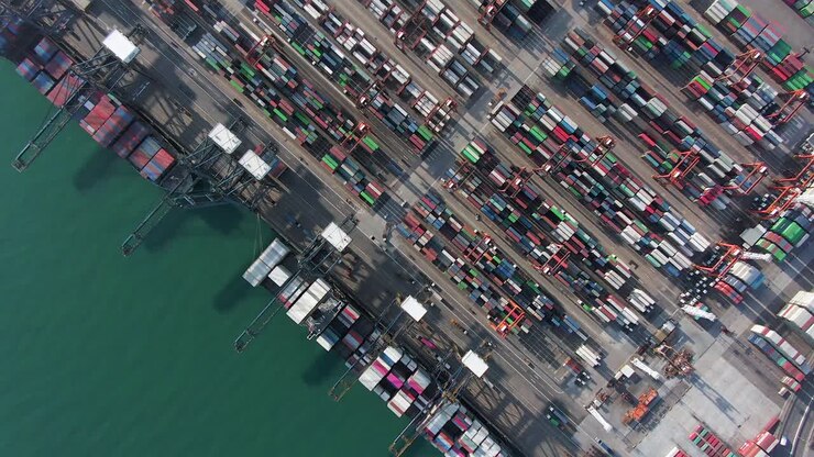 Large Container Ship docked at Hong Kong commercial port, top down aerial view including Stacks of Shipping containers on a holding platform