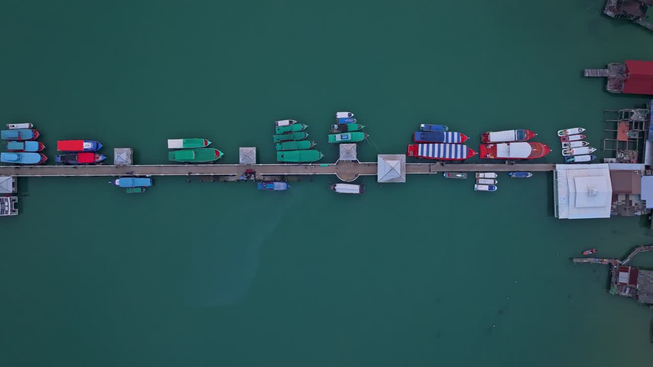 Molerlandsby og fiskebåde hviler på det turkise hav ved Koh Chang, Thailand