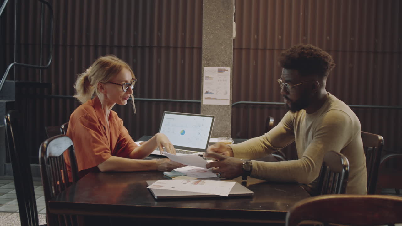 Colleagues Working Away From Office In Modern Cafe