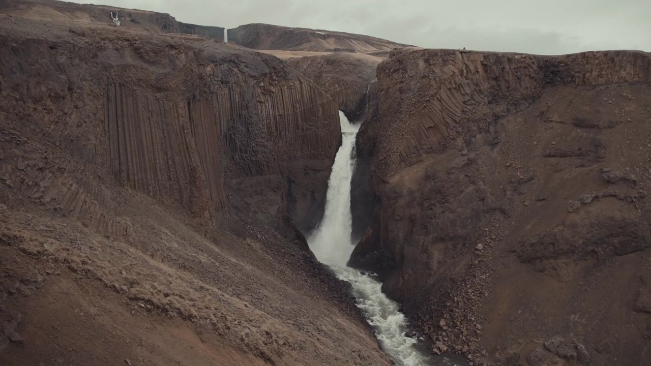 Maestosa cascata che scorre attraverso un canyon con colonne di basalto
