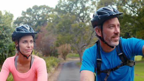 Pareja-Interactuando-Cara-A-Cara-Mientras-Anda-En-Bicicleta