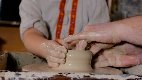 potter showing how to work with ceramic in pottery studio