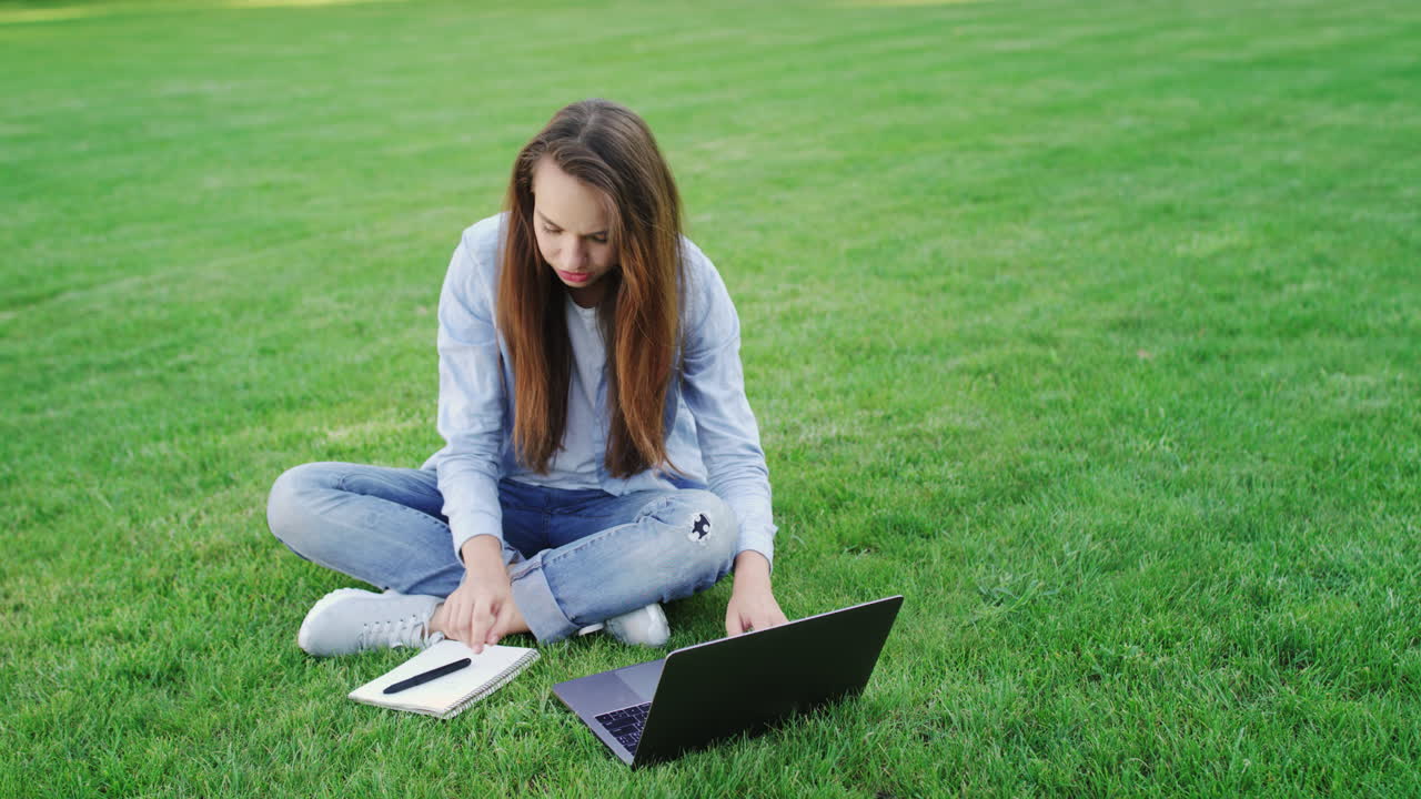 Woman student working on laptop computer in college campus. Freelance work