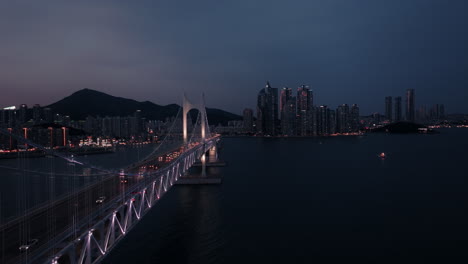 illuminated suspension bridge over a city at twilight
