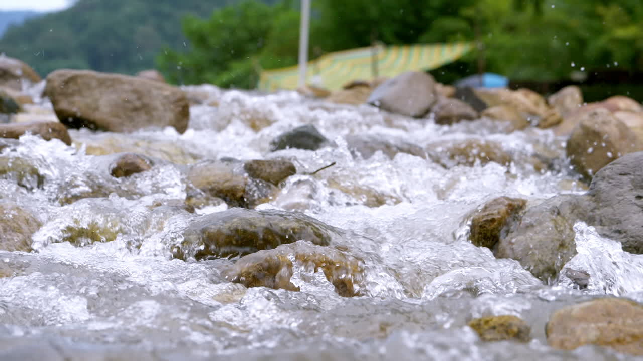 슬로우 모션으로 흐르는 풍부한 강 돌 바위를 통해 흐르는 맑은 스트림