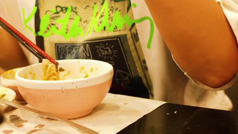 person savoring hotpot soup with chopsticks and spoon