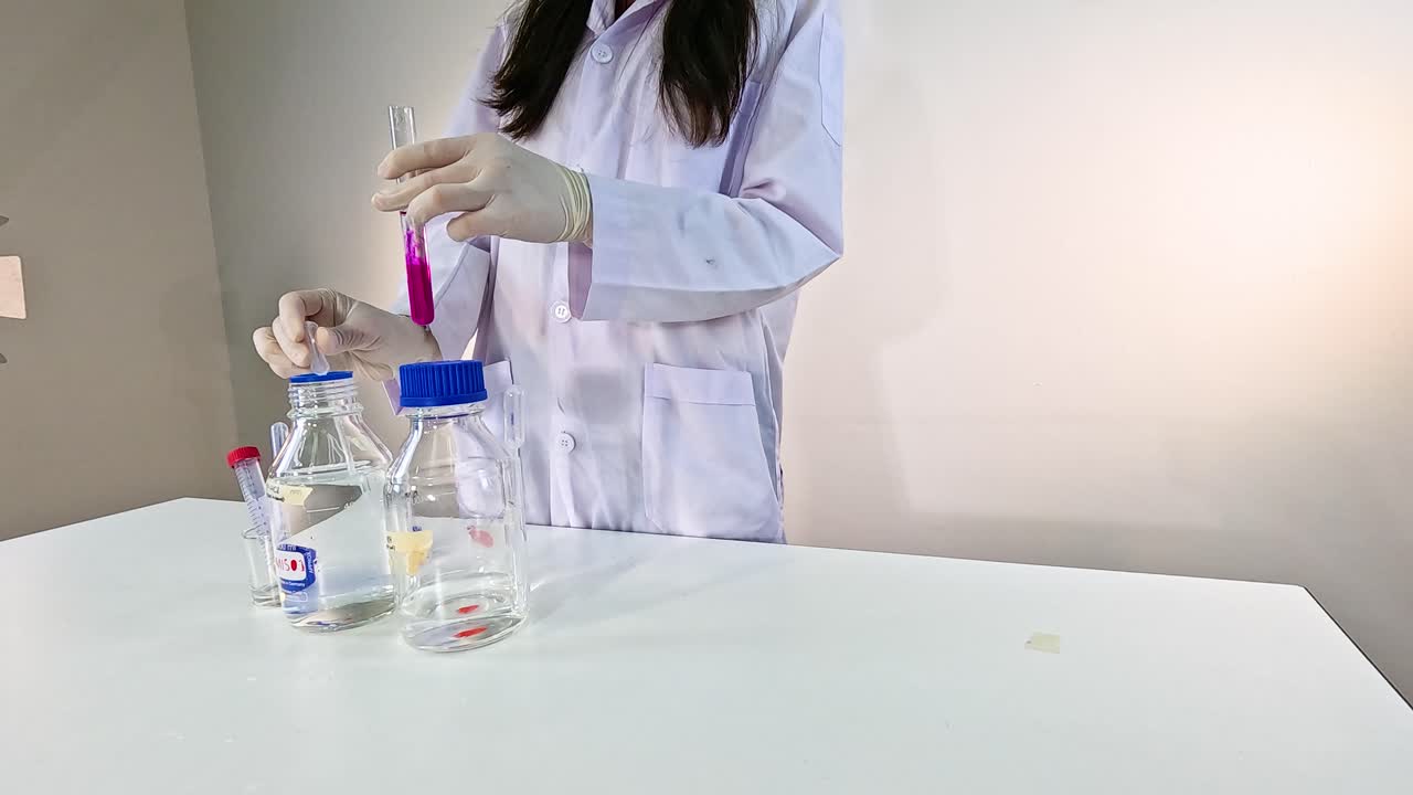 Scientist performs a chemical reduction experiment using potassium permanganate in a controlled laboratory setting