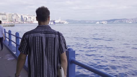 young man walking by the sea.